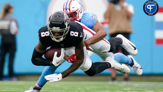 Kyle Pitts (8) is pulled down by Tennessee Titans cornerback Eric Garror (33) during the second quarter at Nissan Stadium.