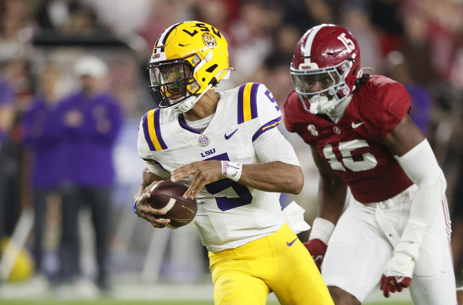 Jayden Daniels (5) carries the ball for a first down against the Alabama Crimson Tide during the first half at Bryant-Denny Stadium.