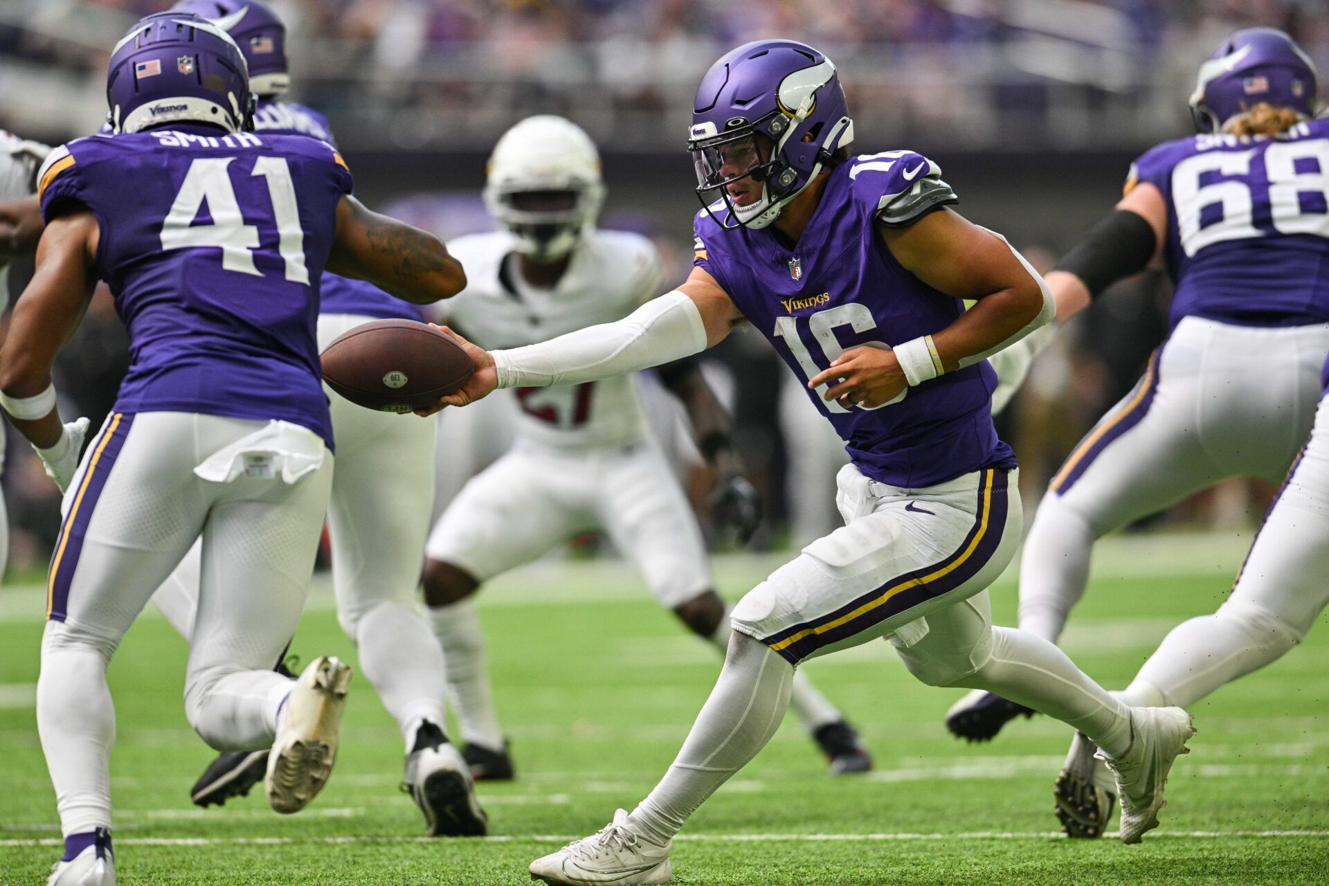 Minnesota Vikings QB Jaren Hall (16) hands the ball off to RB Abram Smith (41).