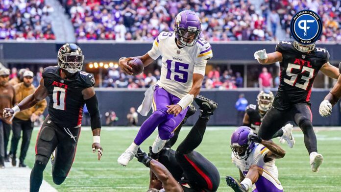 Minnesota Vikings quarterback Joshua Dobbs (15) jumps over Atlanta Falcons defensive tackle Kentavius Street (75) during the second half at Mercedes-Benz Stadium.