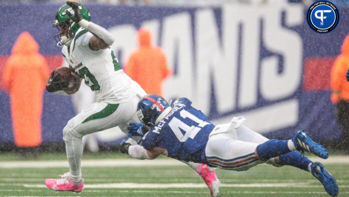 New York Jets running back Breece Hall (20) breaks a tackle by New York Giants linebacker Micah McFadden (41).