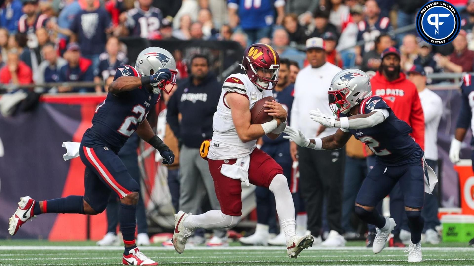 Washington Commanders quarterback Sam Howell (14) runs the ball during the first half against the New England Patriots at Gillette Stadium.