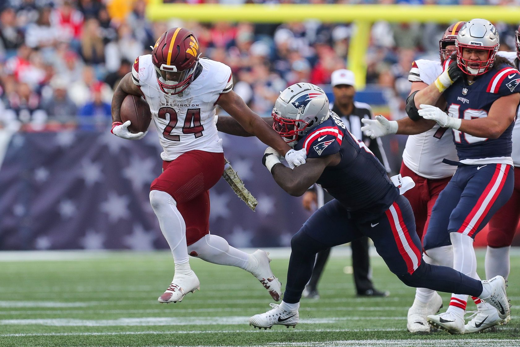 Washington Commanders running back Antonio Gibson (24) stiff arms New England Patriots linebacker Ja'Whaun Bentley (8) during the second half at Gillette Stadium.