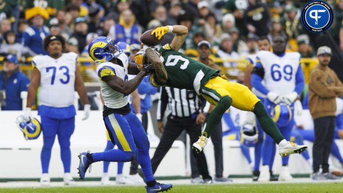 Green Bay Packers wide receiver Christian Watson (9) makes a leaping catch in front of Los Angeles Rams defensive back Russ Yeast (2) during the fourth quarter at Lambeau Field.