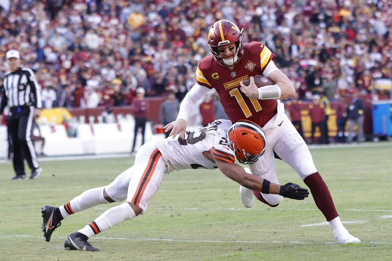 Washington Commanders QB Carson Wentz (11) runs with the ball against the Cleveland Browns.