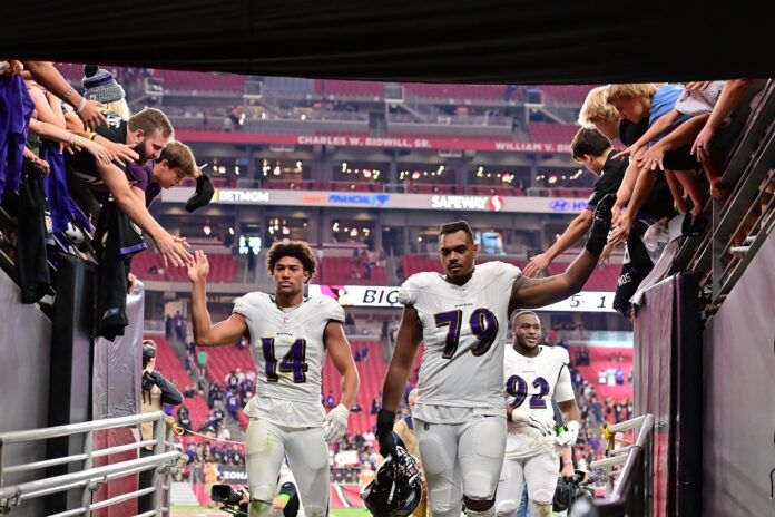 Baltimore Ravens safety Kyle Hamilton (14) and offensive tackle Ronnie Stanley (79) celebrate with fans after beating the Arizona Cardinals at State Farm Stadium.