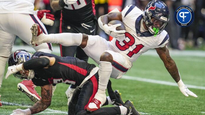 Houston Texans running back Dameon Pierce (31) gets tripped up by an Atlanta Falcons defender at Mercedes-Benz Stadium.