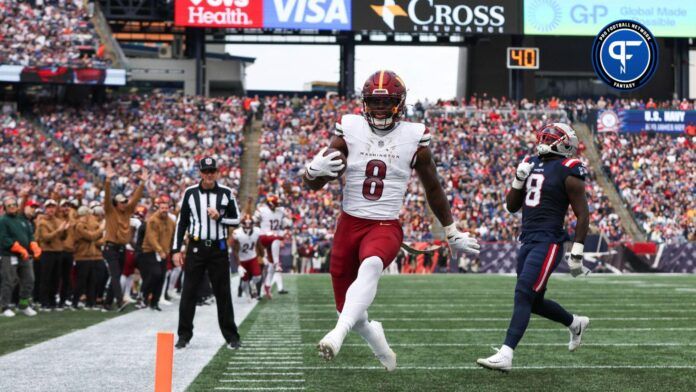 Washington Commanders running back Brian Robinson Jr (8) runs the ball for a touchdown during the first half against the New England Patriots at Gillette Stadium.