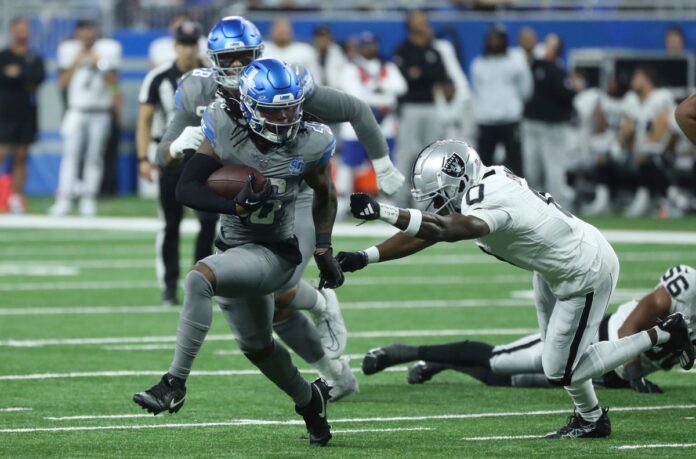 Detroit Lions RB Jahmyr Gibbs (26) breaks free from a would-be tackle against the Las Vegas Raiders.