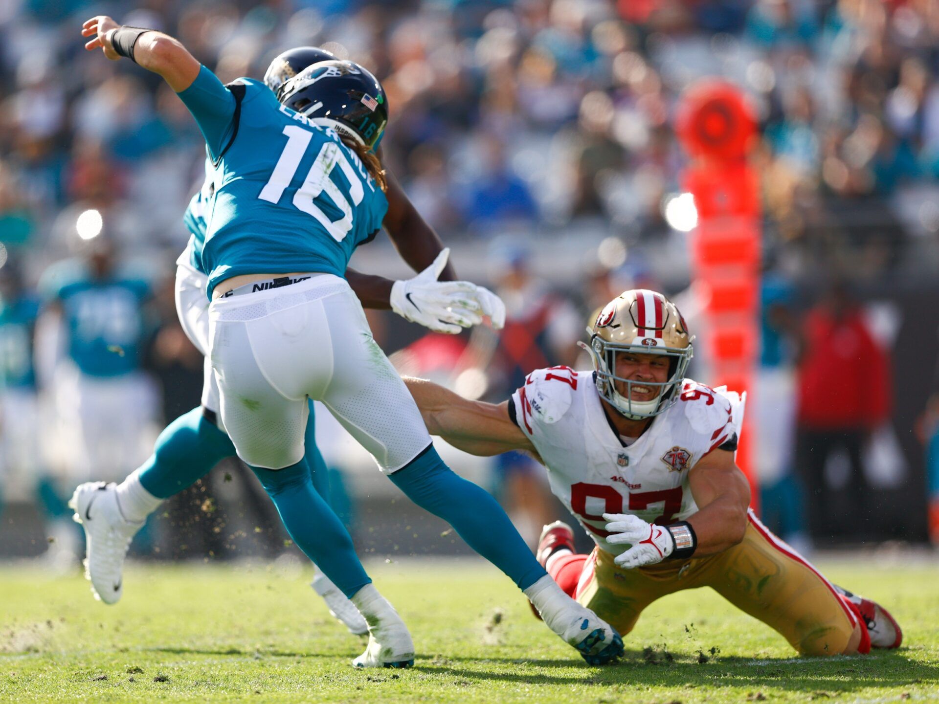 Jacksonville Jaguars quarterback Trevor Lawrence (16) avoids a rush from San Francisco 49ers defensive end Nick Bosa (97) in the second half at TIAA Bank Field.