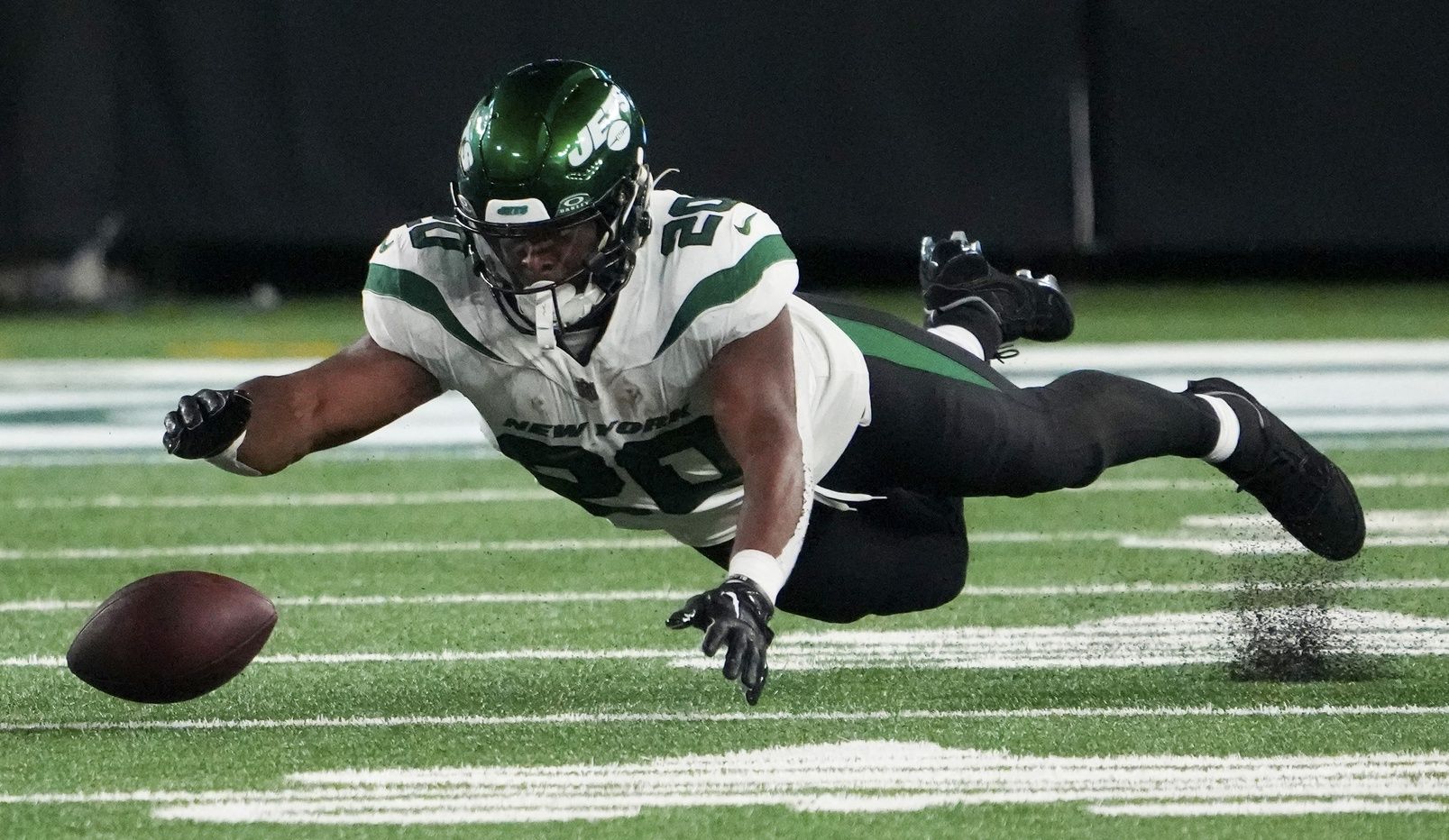 New York Jets running back Breece Hall (20) collects his own fumble against the Los Angeles Chargers during a football game at MetLife Stadium.