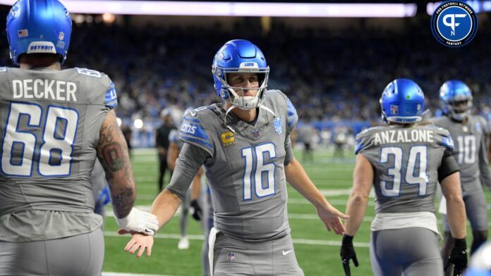 Jared Goff (16) greets his teammates as they run onto the field for warmups before their game against the Las Vegas Raiders at Ford Field.