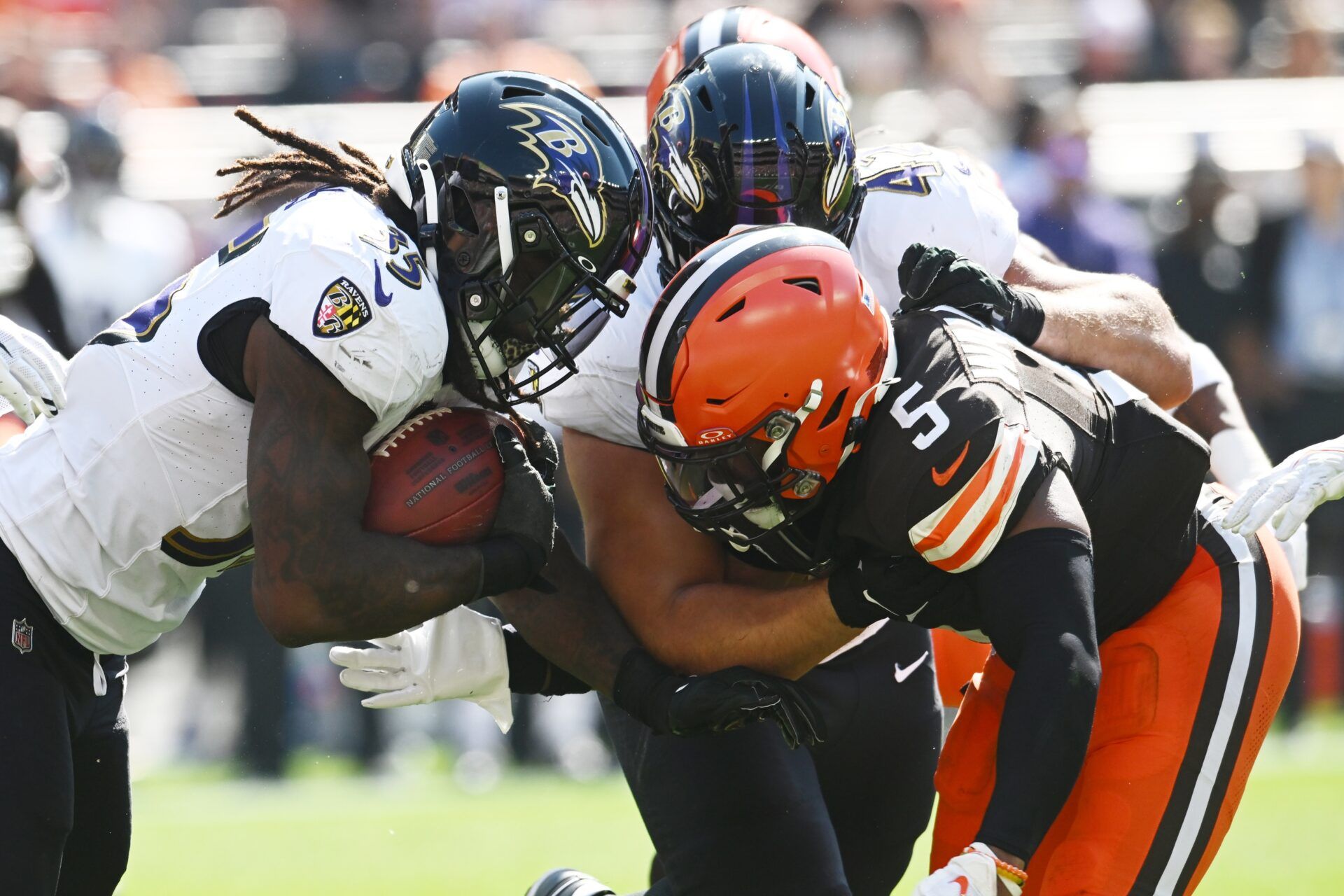 Baltimore Ravens running back Gus Edwards (35) runs with the ball against Cleveland Browns linebacker Anthony Walker Jr. (5) during the first half at Cleveland Browns Stadium.