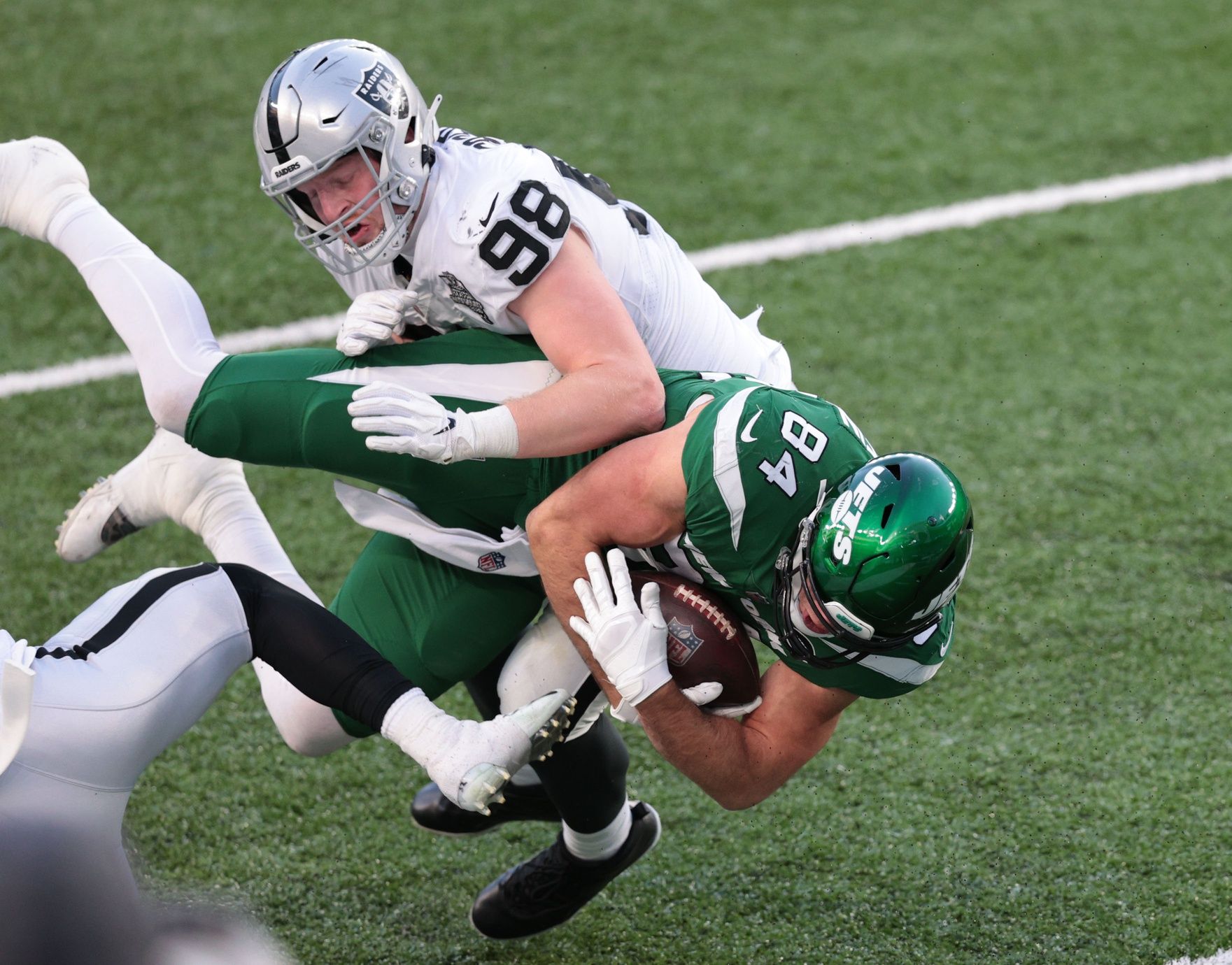 New York Jets tight end Ryan Griffin (84) is tackled by Las Vegas Raiders defensive end Maxx Crosby (98) in the second half of a NFL game at MetLife Stadium.