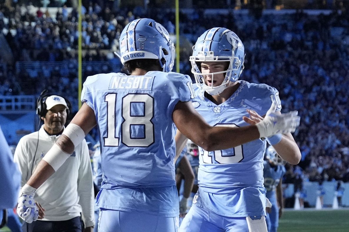 North Carolina QB Drake Maye (10) celebrates with a teammate after a touchdown.