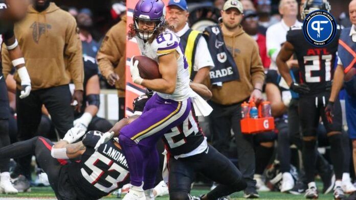 Minnesota Vikings TE T.J. Hockenson (87) tries to break away from tackles against the Atlanta Falcons.