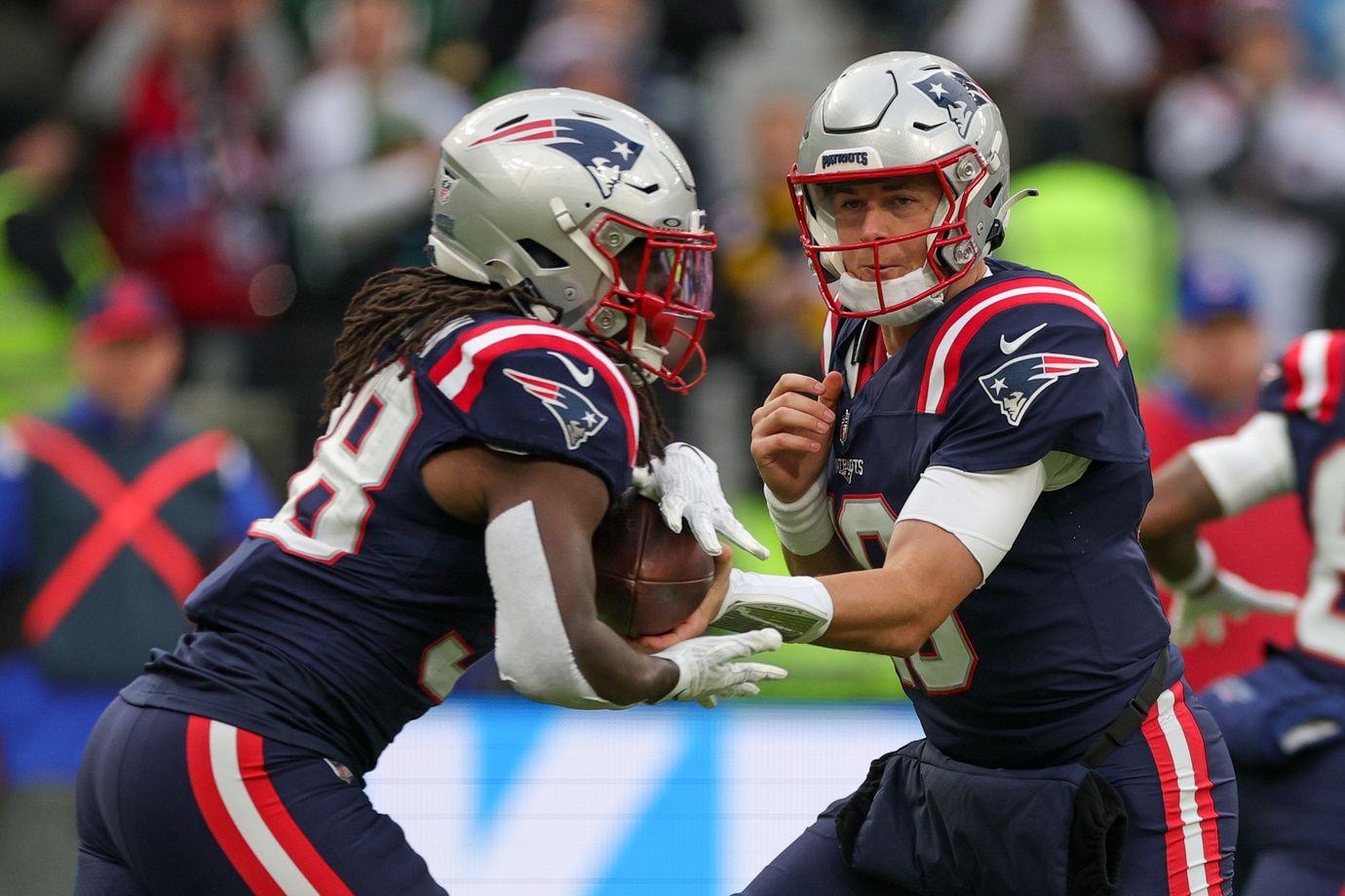 New England Patriots QB Mac Jones (10) hands the ball off to RB Rhamondre Stevenson (38).