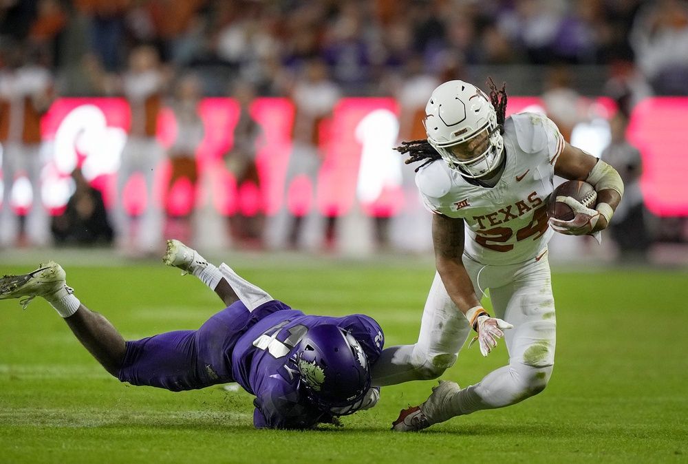 Texas Longhorns RB Jonathon Brooks (24) gets tackled by a TCU defender.