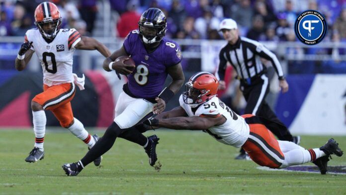 Baltimore Ravens quarterback Lamar Jackson (8) runs with the ball against Cleveland Browns defensive end Ogbo Okoronkwo (54) during the second half at M&T Bank Stadium.