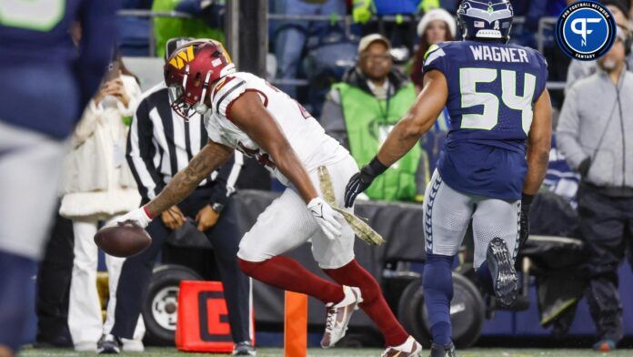 Antonio Gibson (24) reaches across the goal line for a touchdown after making a reception against the Seattle Seahawks during the fourth quarter at Lumen Field.