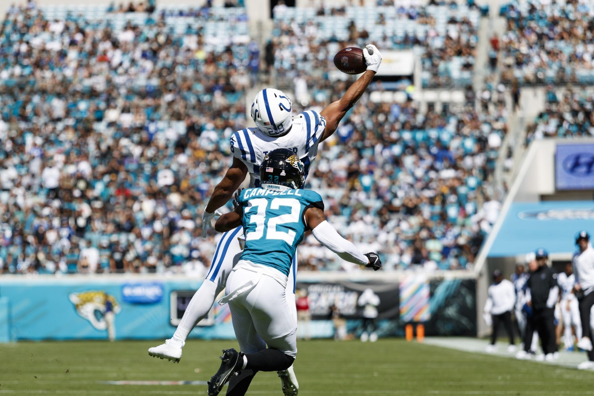 Indianapolis Colts RB Jonathan Taylor (28) attempts to catch the ball under pressure from Jacksonville Jaguars CB Tyson Campbell (32).