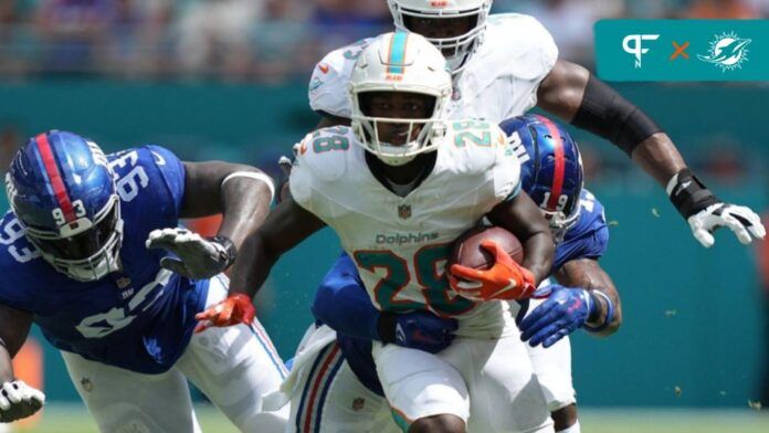 De'Von Achane (28) breaks free for a gain as New York Giants safety Isaiah Simmons (19) closes in on the play during the first half of an NFL game at Hard Rock Stadium.