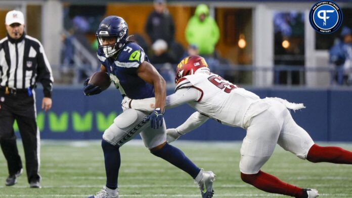 Seattle Seahawks running back Kenneth Walker III (9) rushes against Washington Commanders linebacker Jamin Davis (52) during the third quarter at Lumen Field.