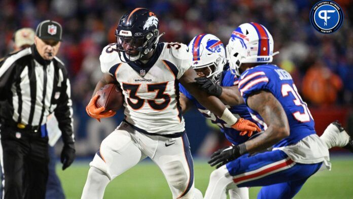 Javonte Williams (33) is pushed out of bounds by Buffalo Bills defenders in the fourth quarter at Highmark Stadium.