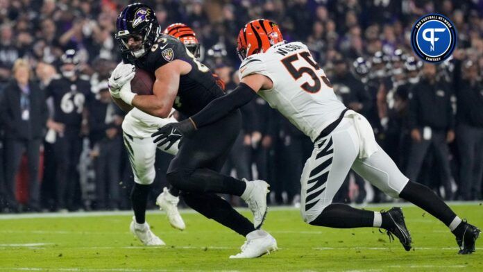 Baltimore Ravens TE Mark Andrews (89) fights a tackle from Cincinnati Bengals LB Logan Wilson (55).