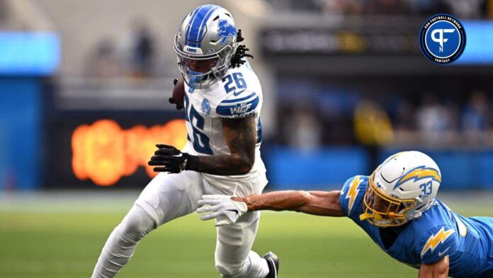 Detroit Lions running back Jahmyr Gibbs (26) runs the ball past Los Angeles Chargers cornerback Deane Leonard (33) during the first half at SoFi Stadium.