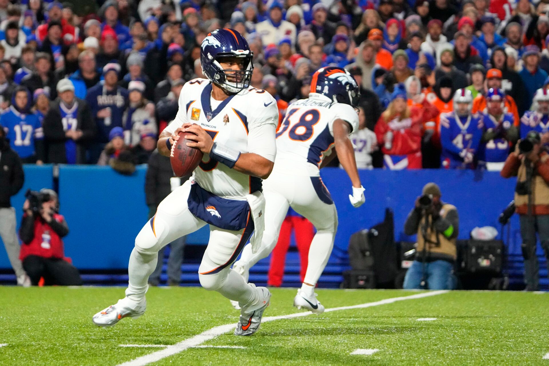 Denver Broncos quarterback Russell Wilson (3) rolls out looking to pass the ball against the Buffalo Bills during the first half at Highmark Stadium.