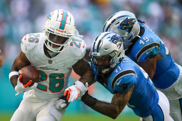 Miami Dolphins running back De'Von Achane (28) runs with the football against Carolina Panthers safety Matthias Farley (41) during the fourth quarter at Hard Rock Stadium.