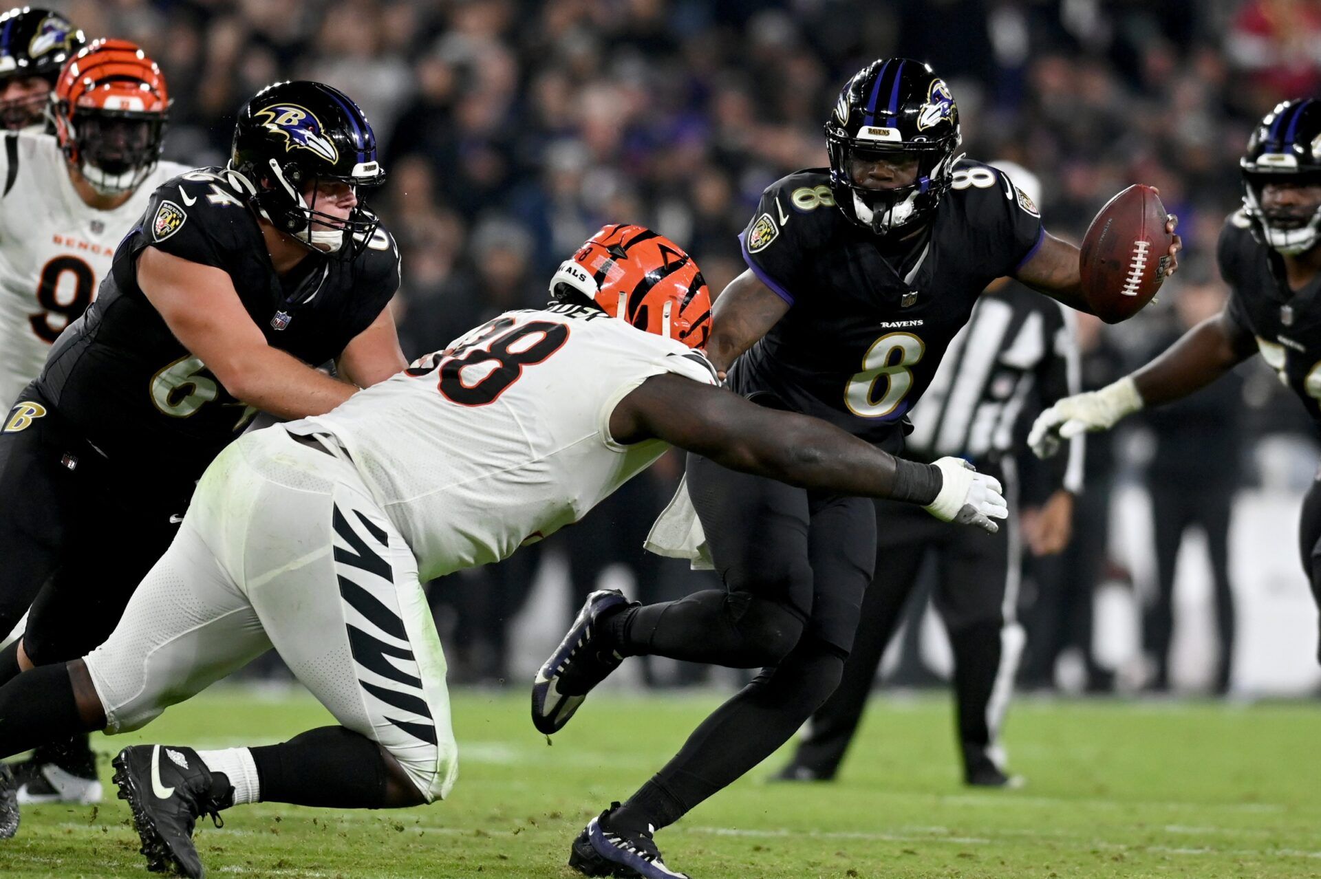 Baltimore Ravens QB Lamar Jackson (8) stiff arms Cincinnati Bengals DT DJ Reader (98).