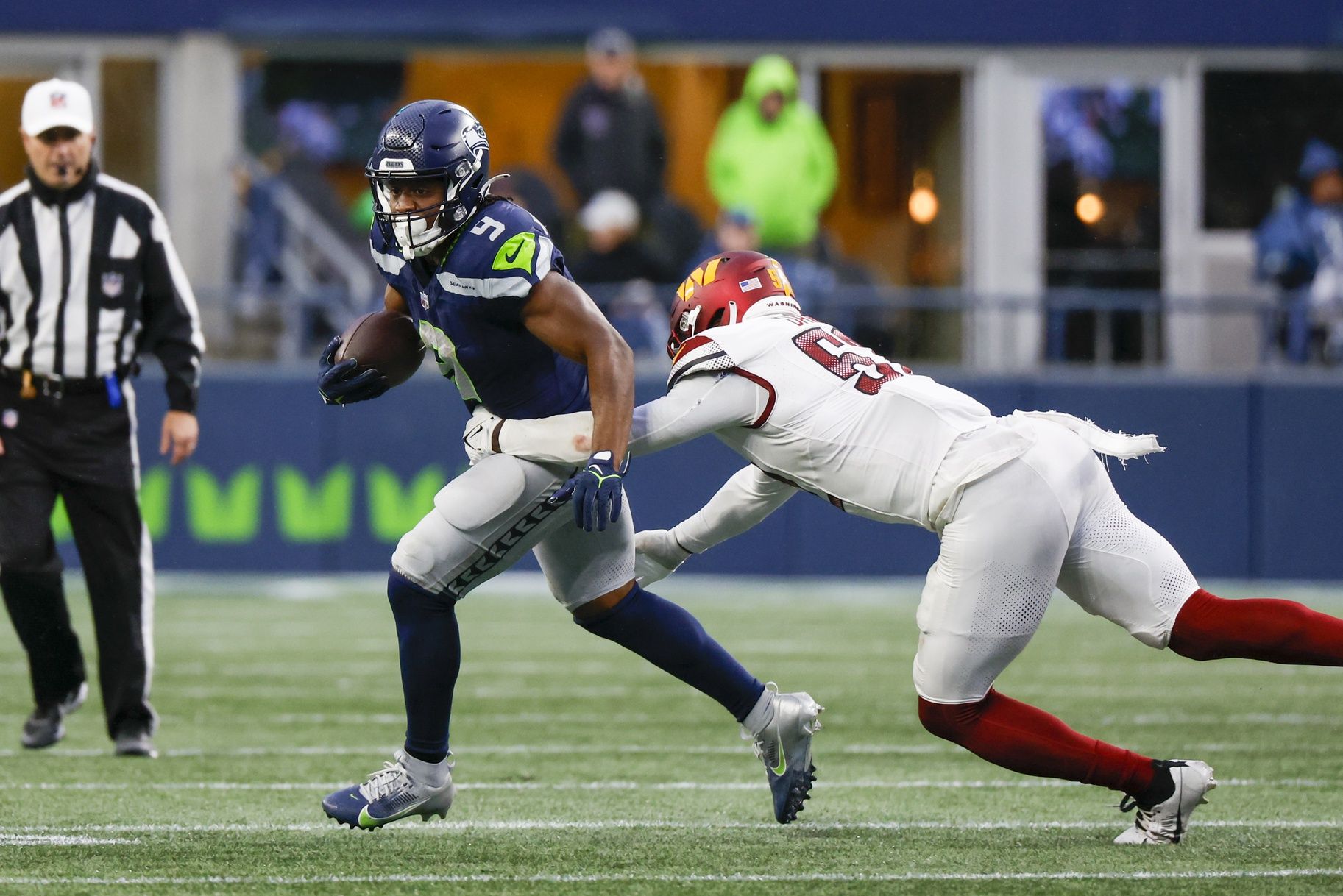 Seattle Seahawks running back Kenneth Walker III (9) rushes against Washington Commanders linebacker Jamin Davis (52) during the third quarter at Lumen Field.