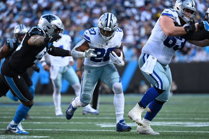 Dallas Cowboys running back Tony Pollard (20) runs as center Tyler Biadasz (63) blocks and Carolina Panthers linebacker Frankie Luvu (49) defends in the fourth quarter at Bank of America Stadium.