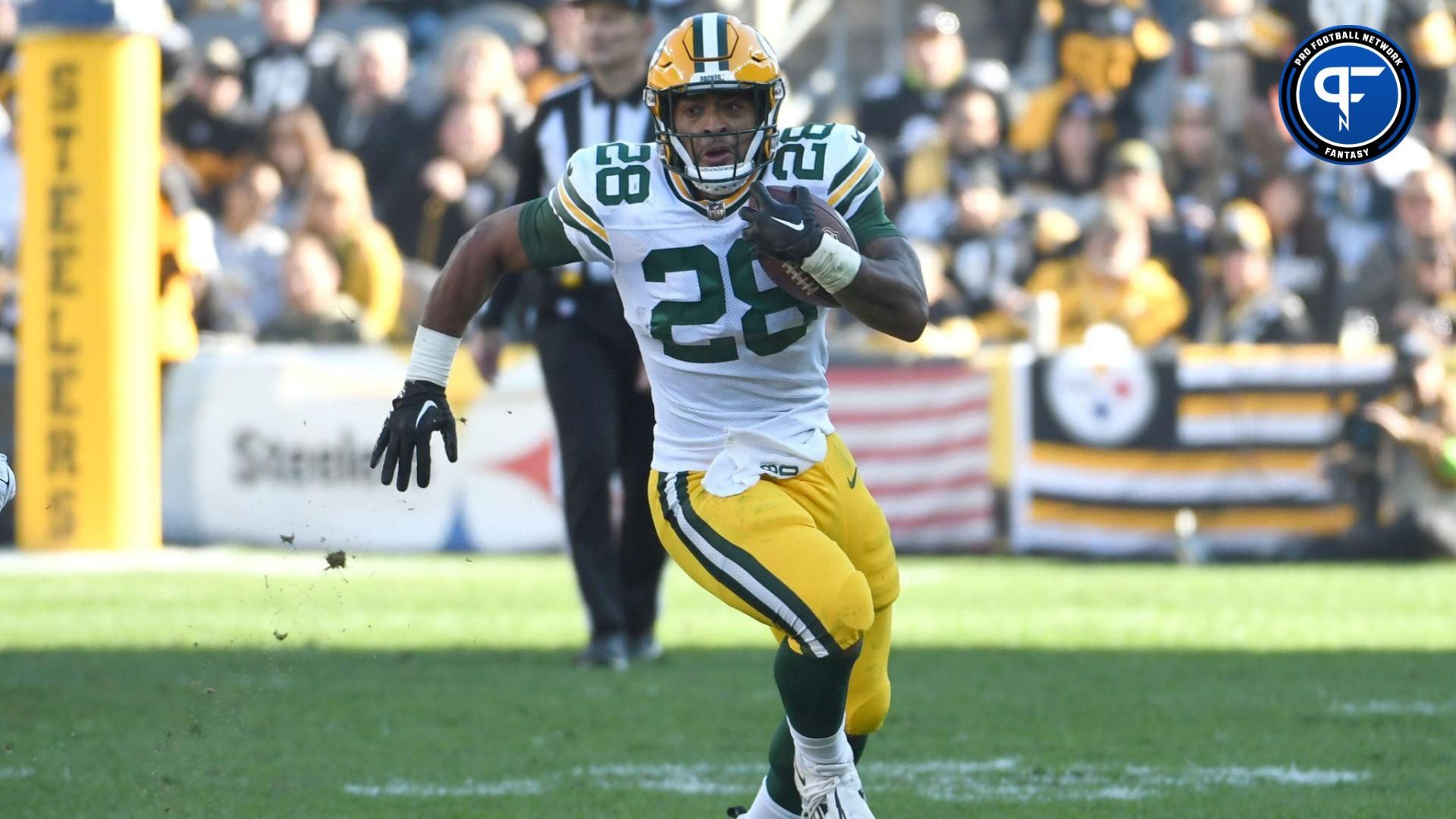 Green Bay Packers running back AJ Dillon (28) moves the ball against the Pittsburgh Steelers during the second quarter at Acrisure Stadium.