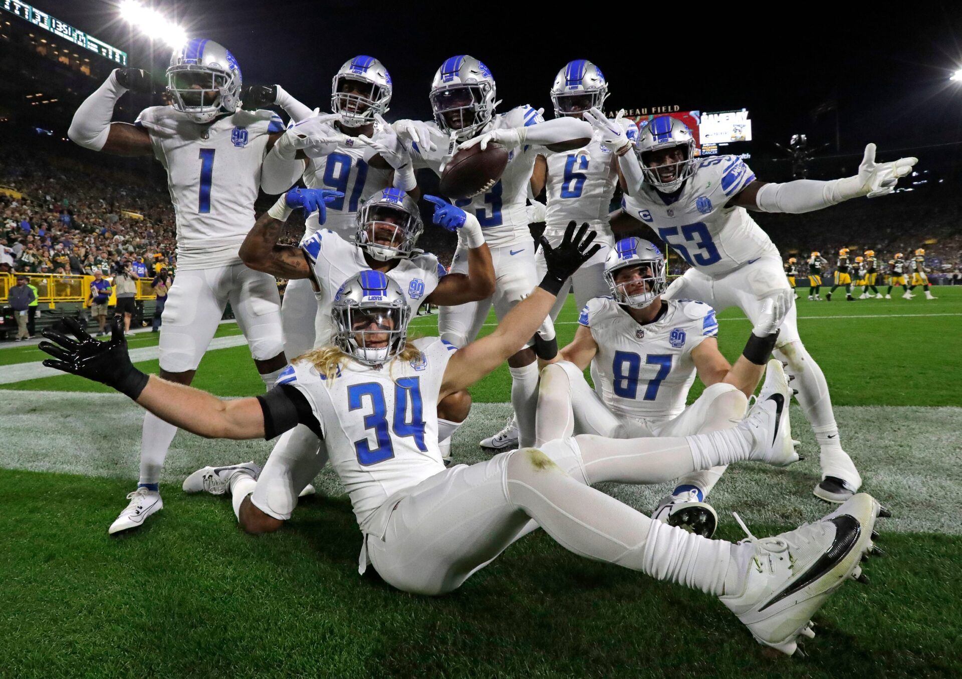 A group of Detroit Lions players celebrate and pose for pictures after a touchdown.