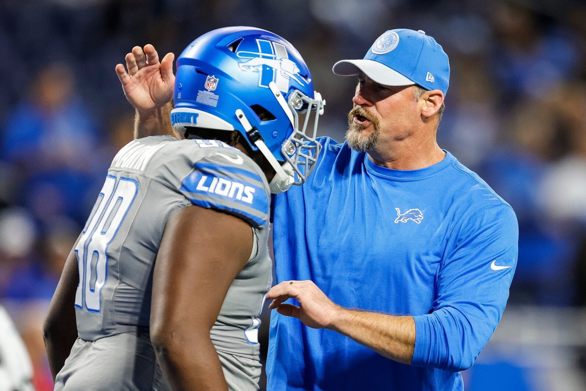 Lions coach Dan Campbell talks to defensive tackle Brodric Martin during warmups before the game against the Raiders.