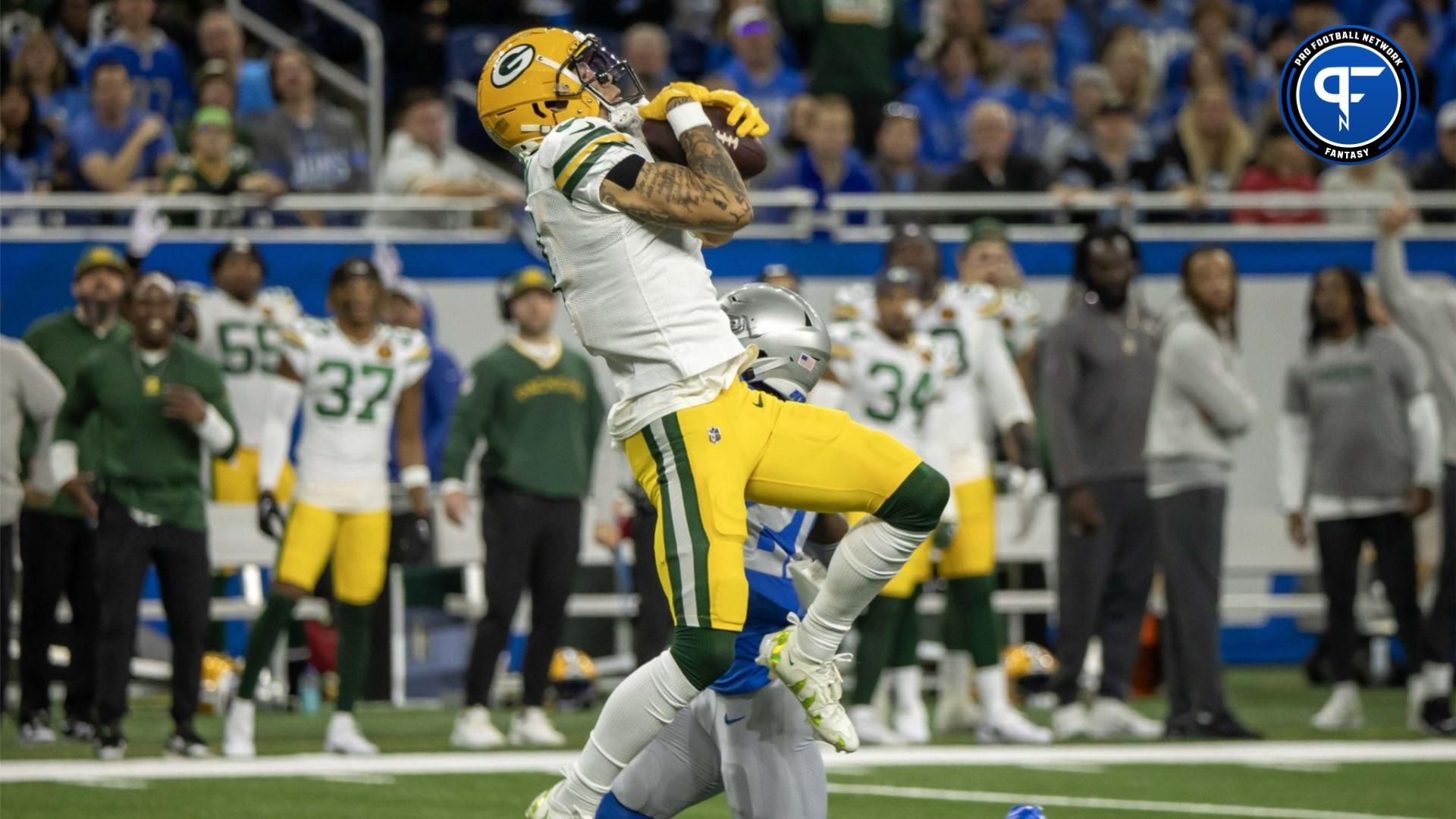 Christian Watson (9) leaps in the air to catch a deep pass against the Detroit Lions in the first quarter during the annual Thanksgiving Day game at Ford Field.