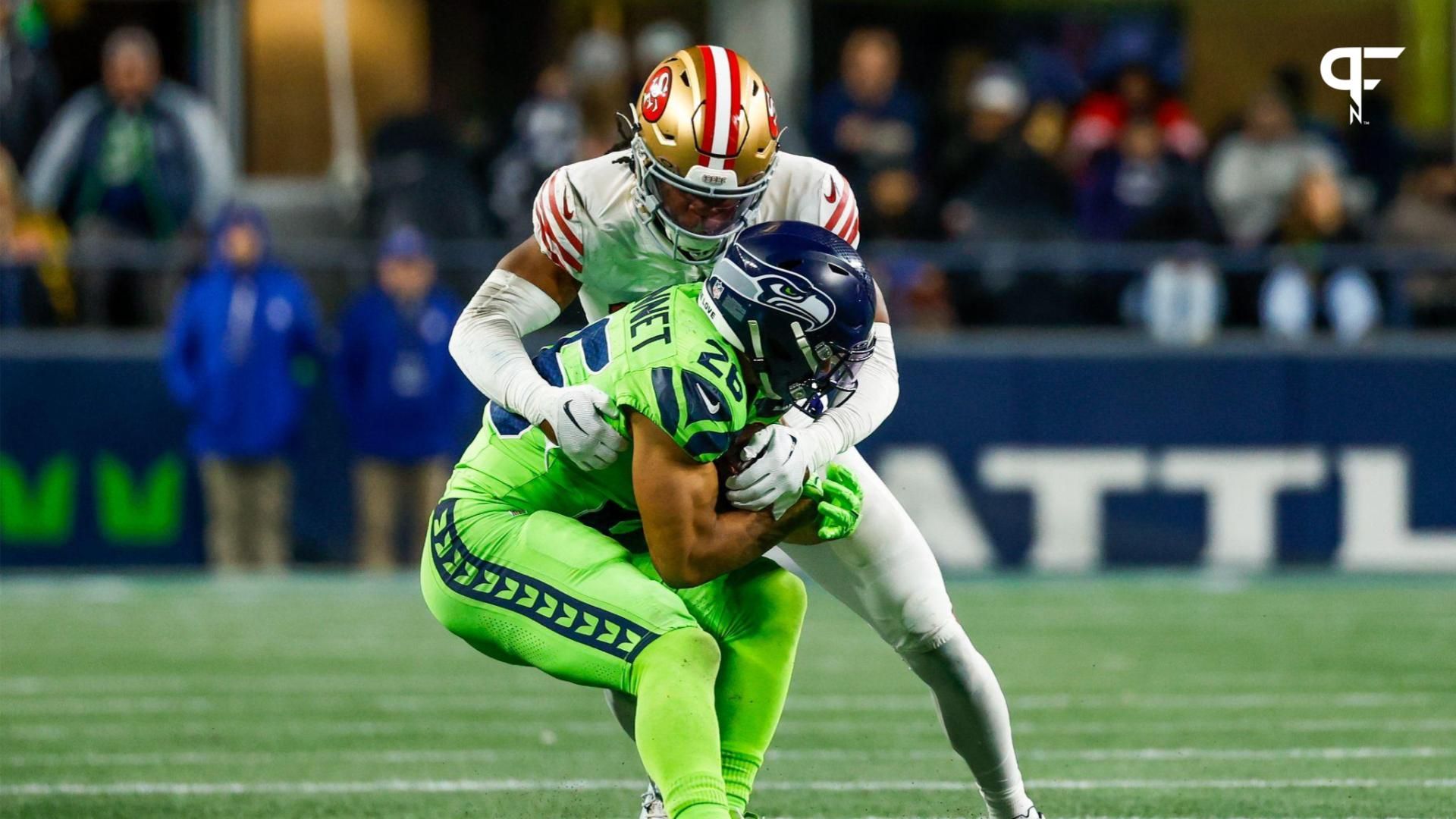 San Francisco 49ers safety Ji'Ayir Brown (27) tackles Seattle Seahawks running back Zach Charbonnet (26) during the fourth quarter at Lumen Field.