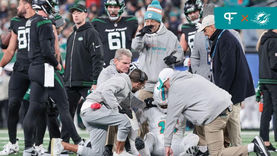 Mike McDaniel talks with linebacker Jaelan Phillips (15) after an apparent injury during the second half against the New York Jets at MetLife Stadium.