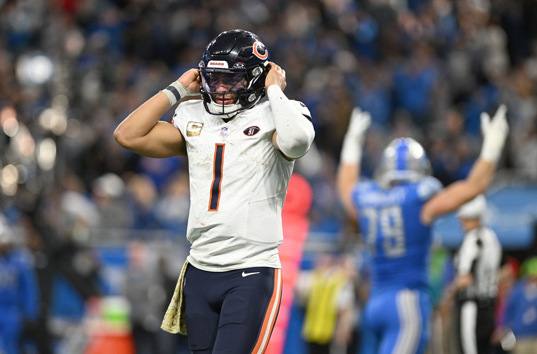 Chicago Bears quarterback Justin Fields (1) walks off the field as Detroit Lions defensive end John Cominsky (79) celebrates in the background after stopping the Bears on a third down play in the fourth quarter at Ford Field.