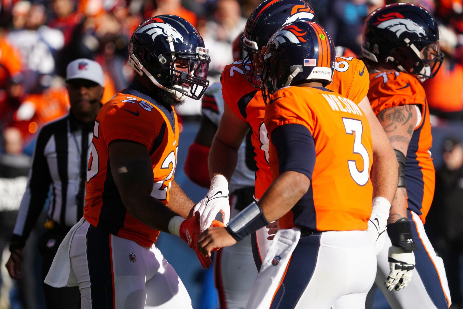 Denver Broncos running back Samaje Perine (25) celebrates his touchdown with quarterback Russell Wilson (3) and tight end Adam Trautman (82) in the first quarter against the Cleveland Browns at Empower Field at Mile High.