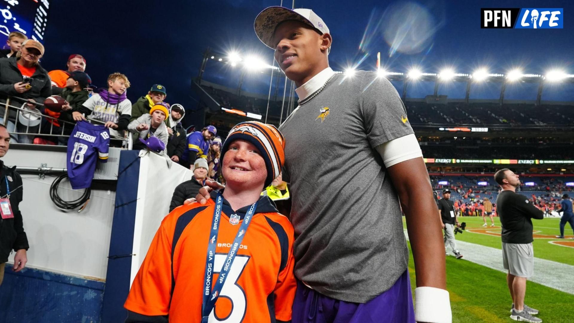 Minnesota Vikings quarterback Joshua Dobbs (15) greets Denver Broncos fan Cameron Onan before the game at Empower Field at Mile High.