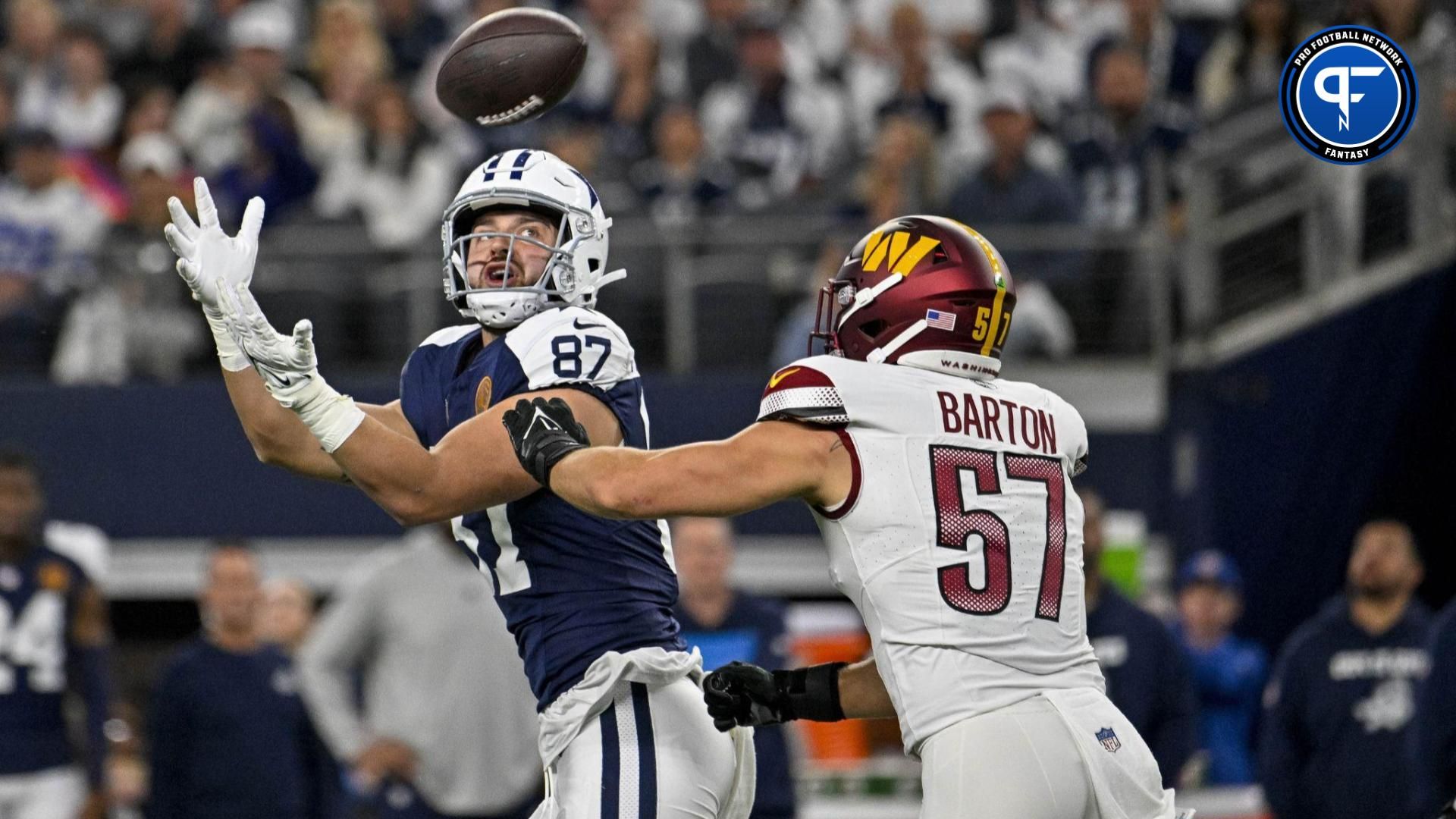 Jake Ferguson (87) catches a pass for a first down over Washington Commanders linebacker Cody Barton (57) during the first quarter at AT&T Stadium.