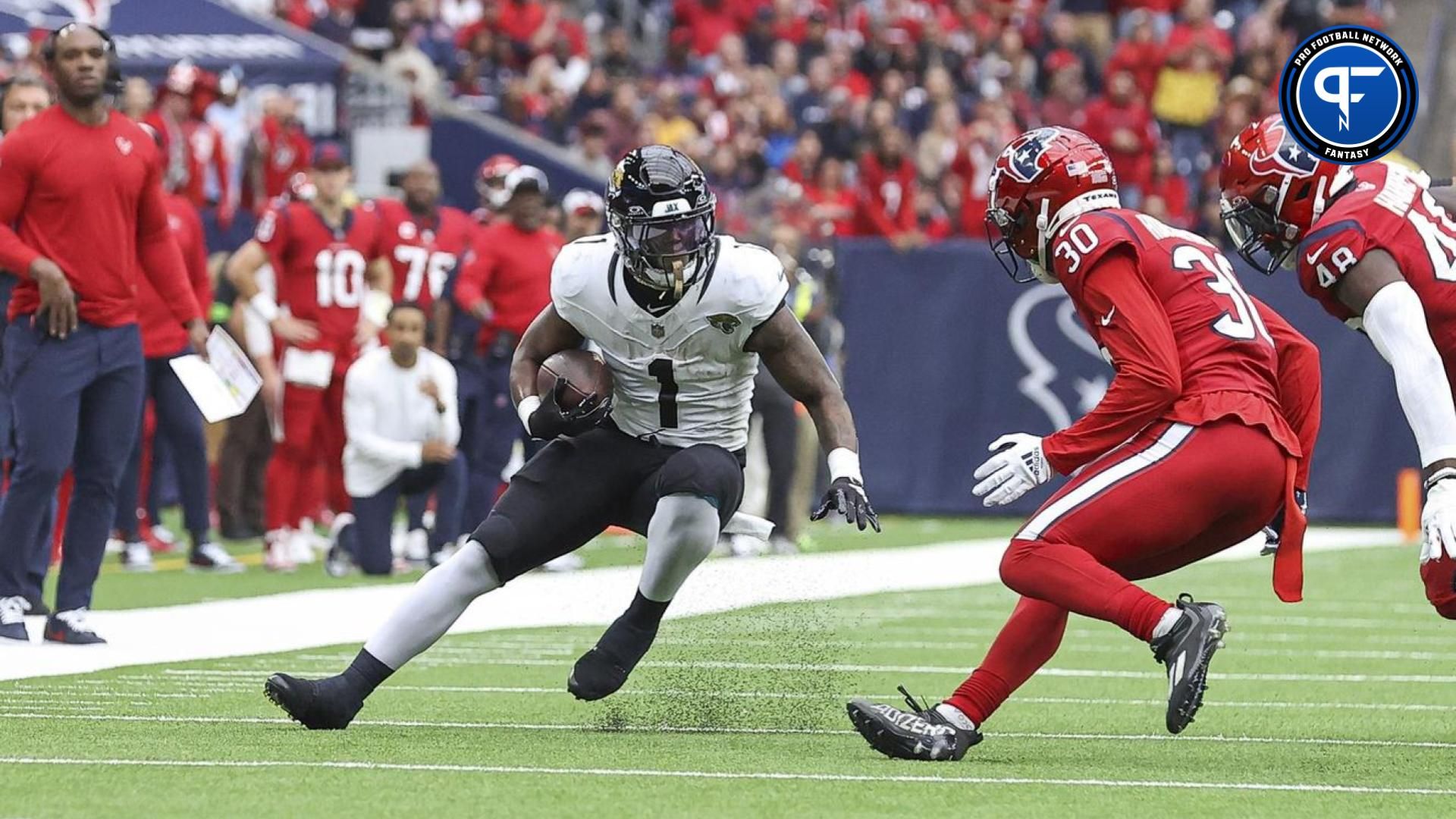 Jacksonville Jaguars running back Travis Etienne Jr. (1) runs with the ball as Houston Texans safety DeAndre Houston-Carson (30) defends on a play during the first quarter at NRG Stadium.