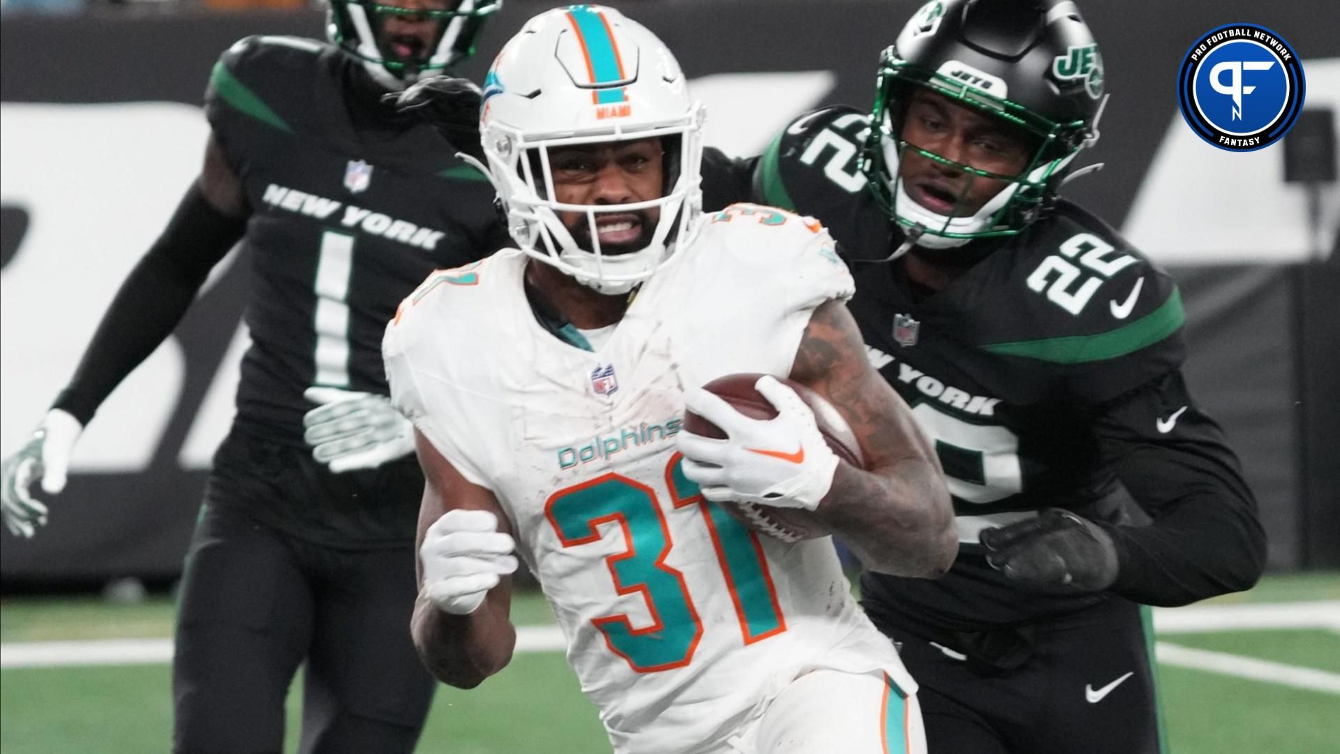 Raheem Mostert of Miami is pursued by Sauce Gardner and Tony Adams of the Jets but not before scoring one of his TD s in the second half as the Miami Dolphins defeated the NY Jets 34-13 at MetLife Stadium.