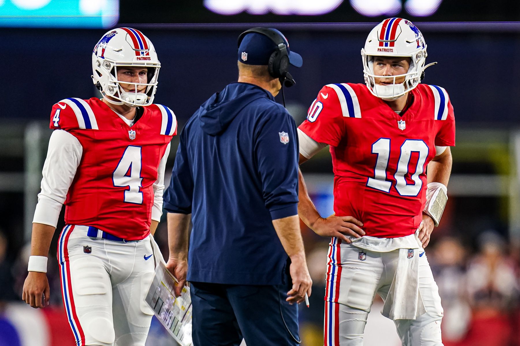 New England Patriots quarterback Mac Jones (10) and quarterback Bailey Zappe (4) talk with offensive coordinator/quarterbacks coach Bill O'Brien in the second quarter at Gillette Stadium.