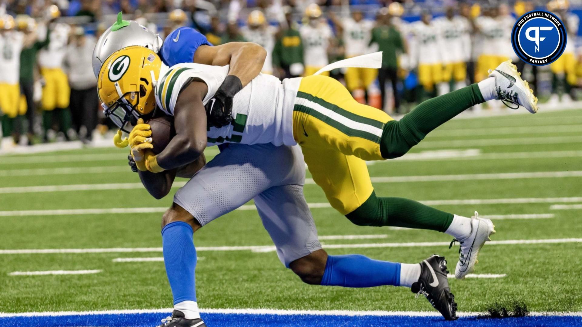 Jayden Reed (11) fights thru a tackle attempt by Detroit Lions safety Brian Branch (32) and score a touchdown in the first quarter during the annual Thanksgiving Day game at Ford Field.