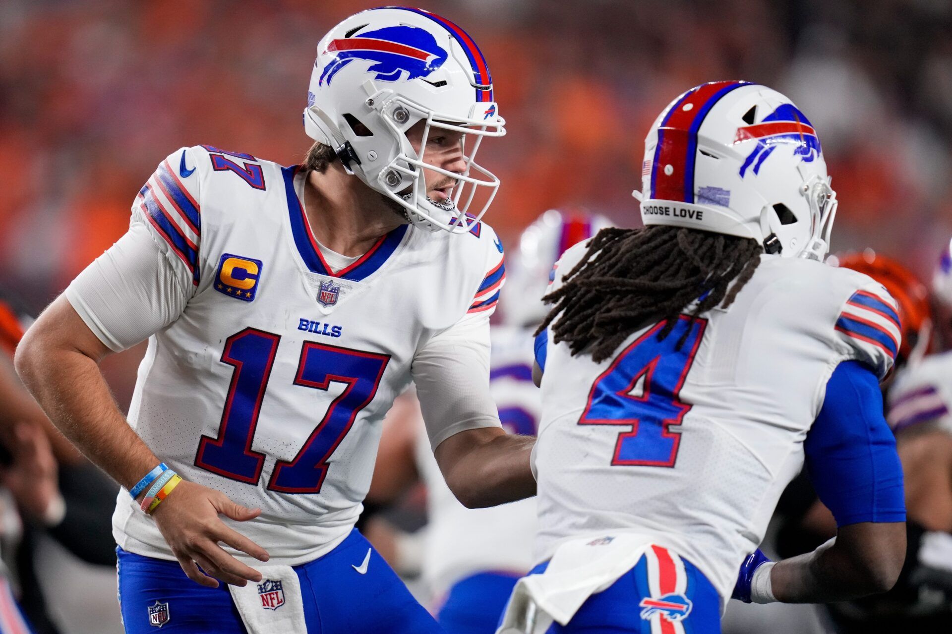 Buffalo Bills QB Josh Allen (17) hands the ball off to RB James Cook (4).